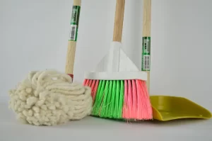 Set of colorful broom, mop, and dustpan with wooden handles