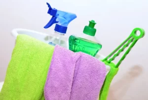 Bright microfiber cloths and cleaning supplies in a plastic bucket