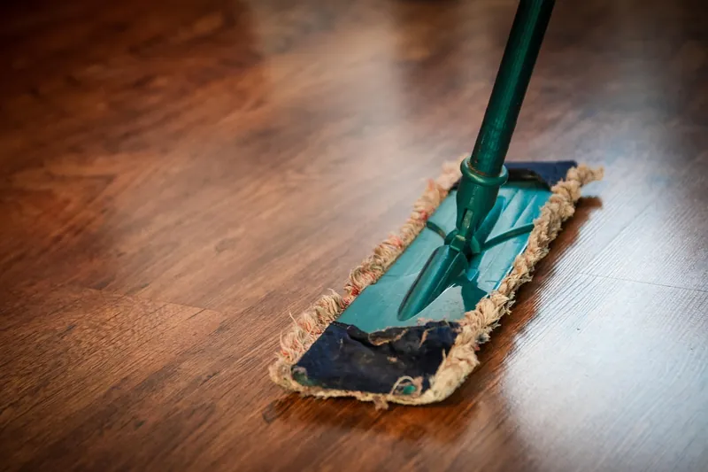 Dust mop on a polished wooden floor ready for cleaning