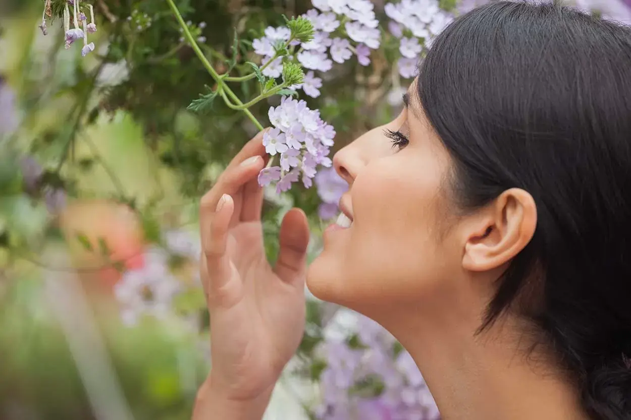 Woman enjoying the scent of natural flowers used in DIY air fresheners in Singapore