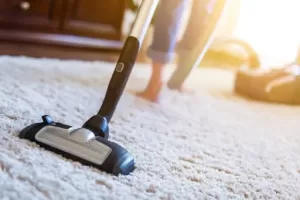 Vacuuming carpet during weekly house cleaning service in Singapore