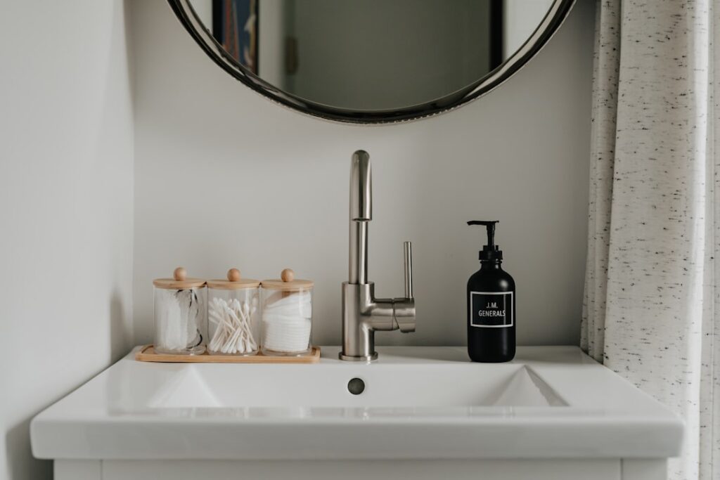 Bathroom sink with mirror, faucet, and soap dispenser