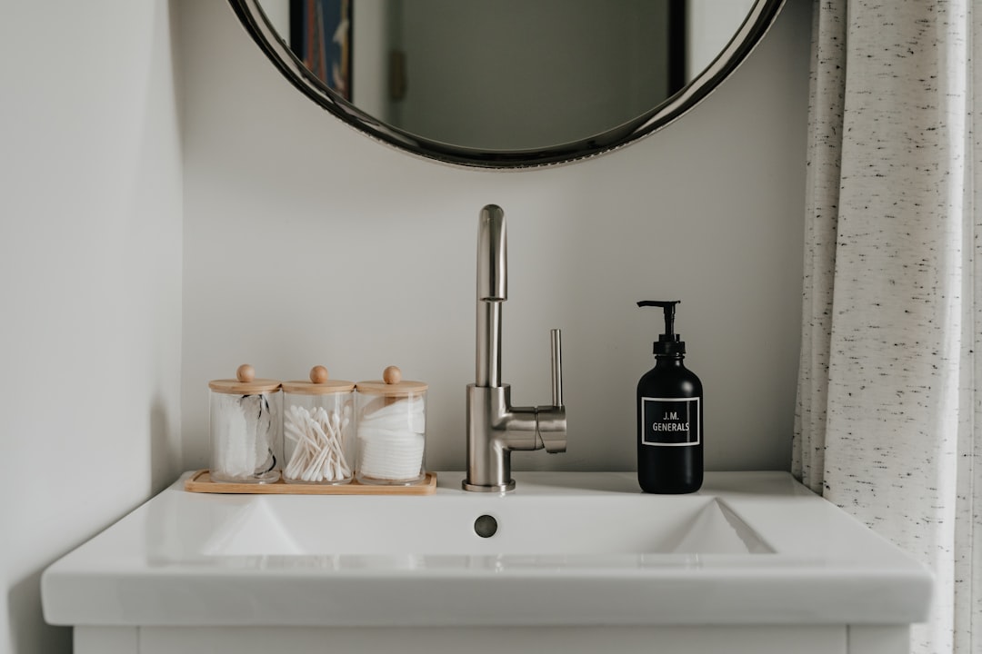 Bathroom sink with mirror, faucet, and soap dispenser