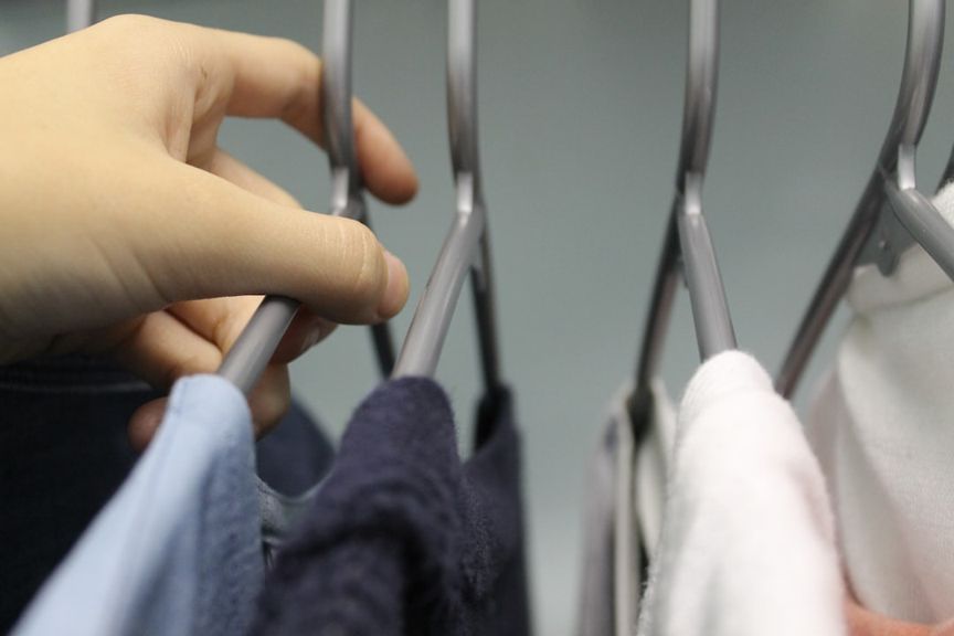 Hand hanging freshly ironed clothes on hangers