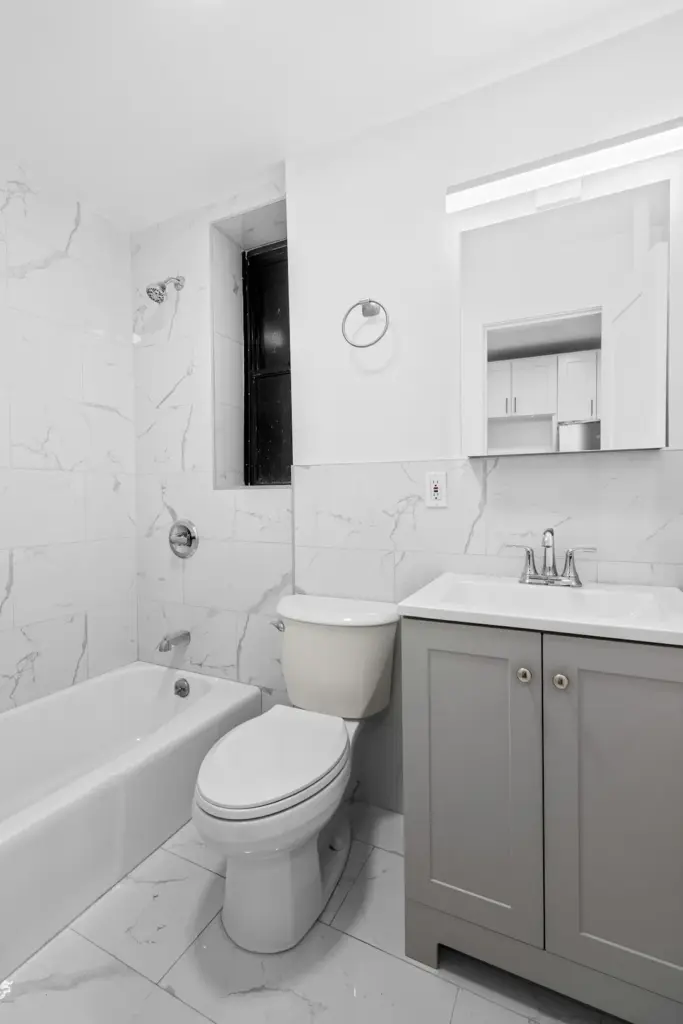 Modern bathroom with bathtub, toilet, and vanity