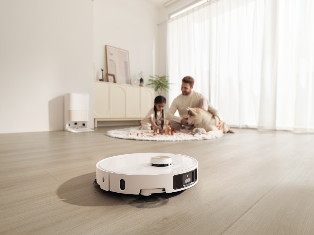 Robot vacuum cleaning floor while family plays with pet in living room.